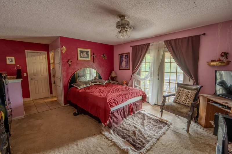 Upstairs bedroom with red walls and a window looking into the trees